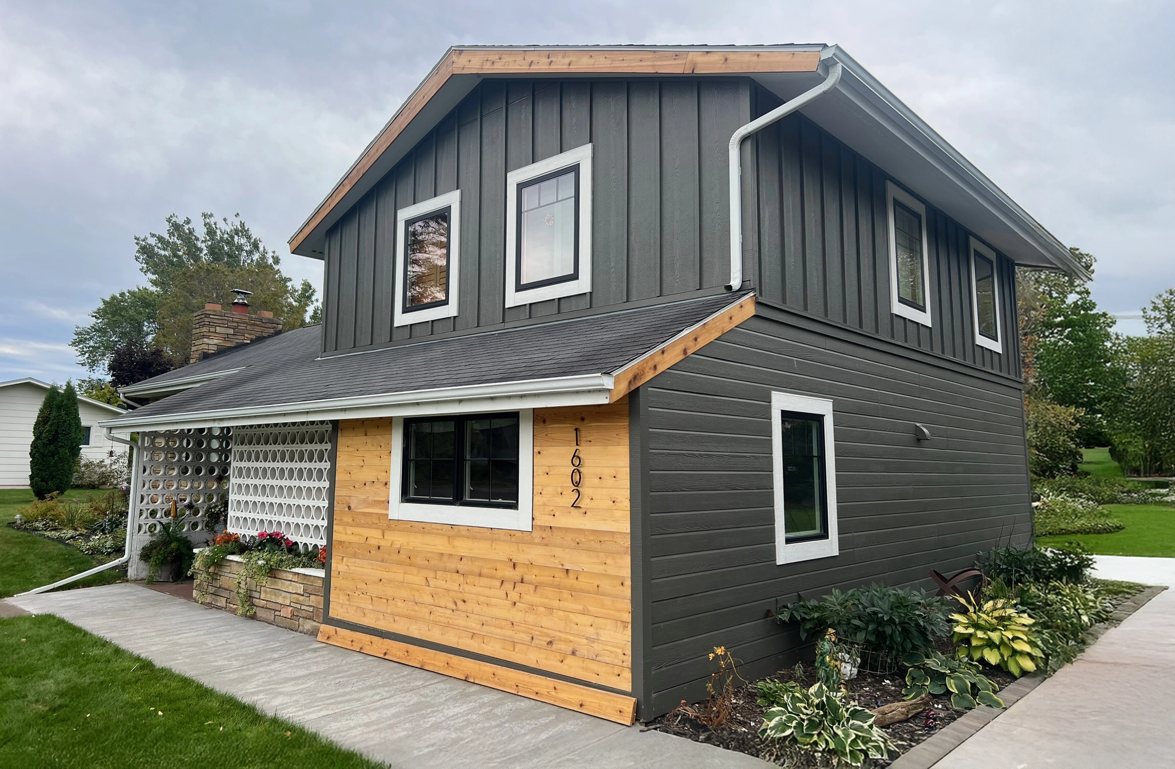 Large house with gray vertical siding and wood accents