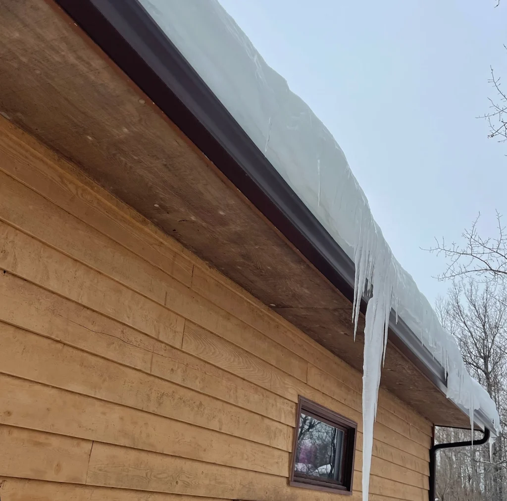 gutters in the winter with snow and icicles